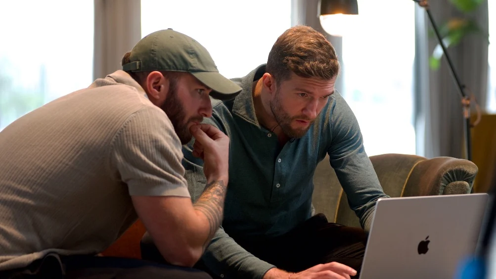 Two men reviewing a diagnostic together on a laptop